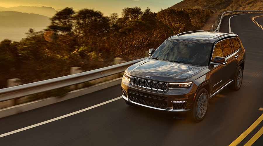 Grand Cherokee driving along highway at sunset