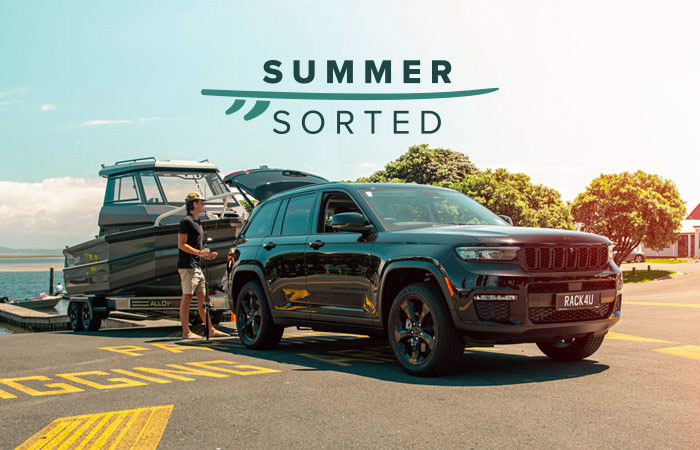Black Jeep Grand Cherokee towing a boat by a loading zoen